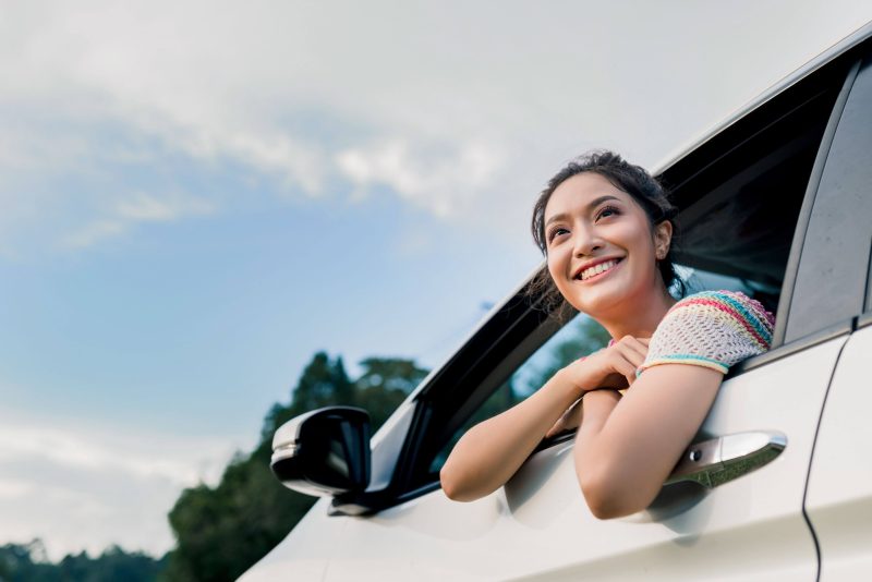 girl hanging outside of car
